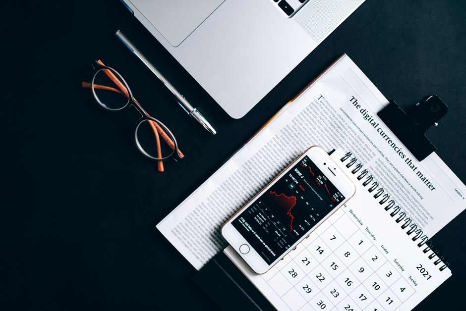 Flat lay of electronic devices and financial documents showcasing digital currency analysis.